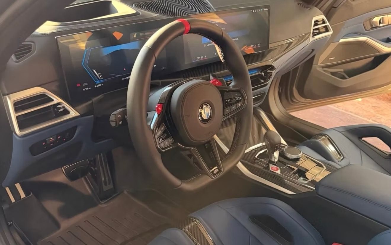 Detailed BMW interior with clean steering wheel, dash and blue leather seats